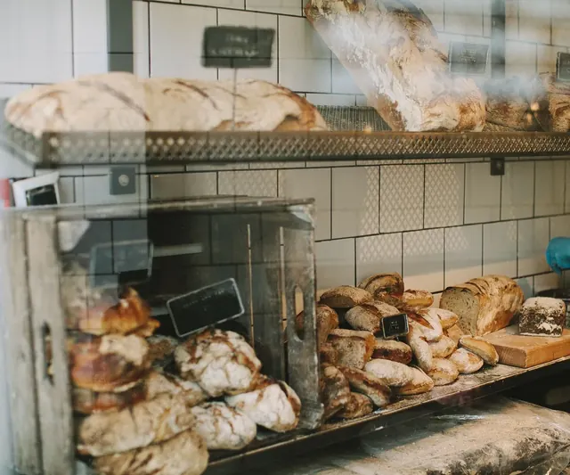 Fresh sourdough loaves on the shelves and counter of a local bakery